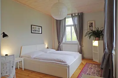 a bedroom with a white bed and a window at Penzion Schola in Noutonice