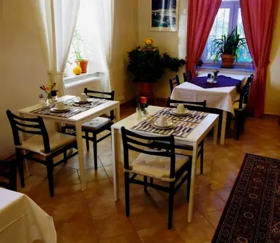 a dining room with two tables and chairs and a table and chairsktop at Penzion Schola in Noutonice