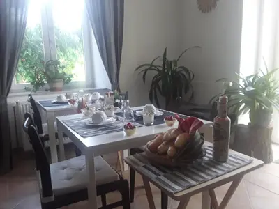 a dining room table with a bottle of wine and bread at Penzion Schola in Noutonice
