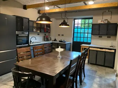a kitchen with a wooden table and some chairs at Penzion Schola in Noutonice