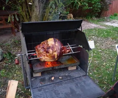 a turkey is cooking in an outdoor grill at Penzion Schola in Noutonice