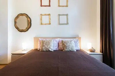 a bedroom with a bed with pillows and a mirror at Victoria Design Stays - Apartment Slavojova in Prague