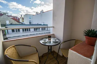 a small table and chairs on a balcony with a window at City Center Apartments near Synagogue in Prague