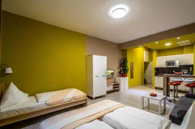 a room with two beds and a green wall at City Center Apartments near Synagogue in Prague