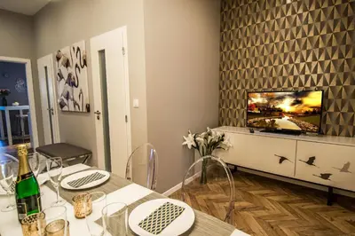 a dining room with a table and a tv at City Center Apartments near Synagogue in Prague