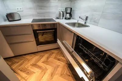 an open dishwasher in a kitchen with a sink at City Center Apartments near Synagogue in Prague