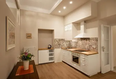 a kitchen with white cabinets and a table at Igor and David Apartments in Prague