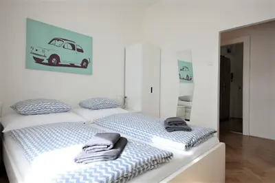 a white bedroom with a bed with towels on it at Angel City Aparthotel in Prague
