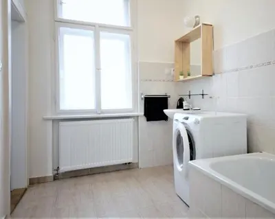a bathroom with a washing machine and a window at Angel City Aparthotel in Prague