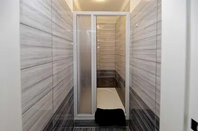 a walk in shower with a bench in a room at Apartments At I.P.Pavlova in Prague