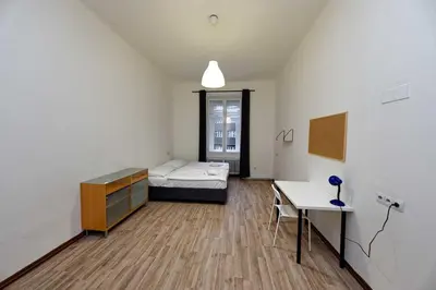 a room with a bed and a desk and a table at Apartments At I.P.Pavlova in Prague