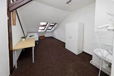 a attic room with a desk and a sink at Apartments At I.P.Pavlova in Prague