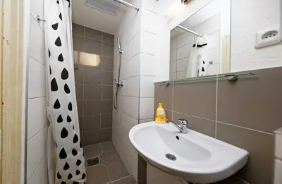 a bathroom with a sink and a mirror and a shower at Apartments At I.P.Pavlova in Prague