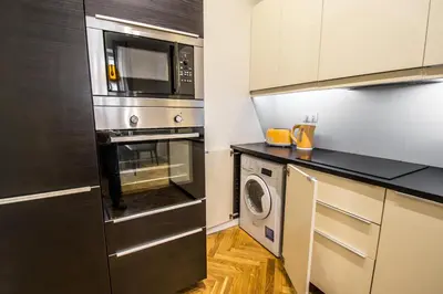 a kitchen with a black counter top and cabinets at Vojtesska Apartment By Ruterra in Prague