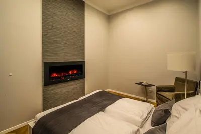a bedroom with a bed and a table with a lamp at Vojtesska Apartment By Ruterra in Prague
