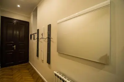 a dining room table with chairs and a large light fixture at Vojtesska Apartment By Ruterra in Prague