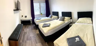 a room with two beds and a bench in it at Hotel Stará Pošta in Zdiby