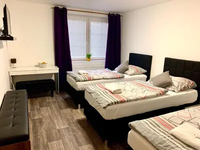 three beds in a room with a window at Hotel Stará Pošta in Zdiby