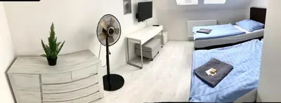 a bedroom with a fan and a bed and a desk at Hotel Stará Pošta in Zdiby