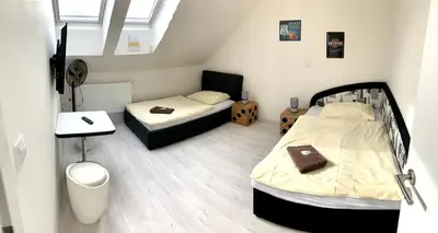 a small room with two beds and a desk at Hotel Stará Pošta in Zdiby