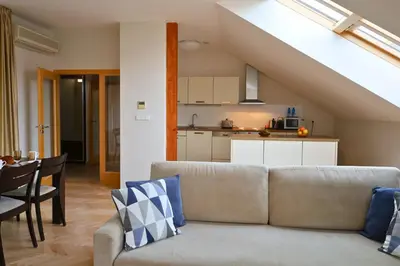 a living room with a couch and a kitchen at Rezidence Ostrovní in Prague