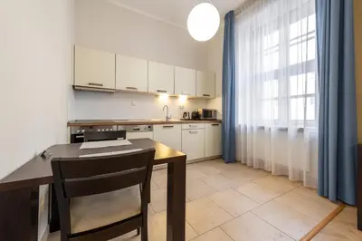 a kitchen with a wooden table and a table and a window at Rezidence Ostrovní in Prague
