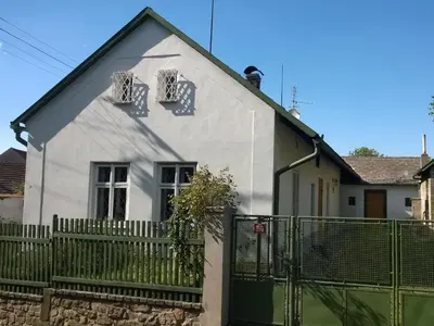 a white house with a green fence at Holiday Home Praskolesy by Interhome in Praskolesy