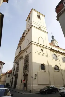 a white building with a clock tower on a street at Apartment Aida in Prague