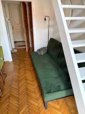 a green couch in a room with a staircase at Apartment Siroka 14 in Prague