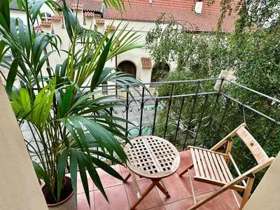a balcony with a table and a chair and a plant at Apartment Siroka 14 in Prague