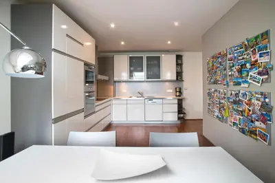 a kitchen with white cabinets and a table and chairs at Luxury Penthouse Apartment in Prague