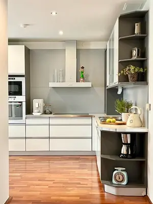 a kitchen with white cabinets and a wooden floor at Luxury Penthouse Apartment in Prague