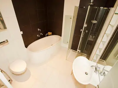 a bathroom with a tub and a toilet and a sink at Luxury Penthouse Apartment in Prague