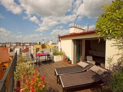 a balcony with a table and chairs on a building at Luxury Penthouse Apartment in Prague