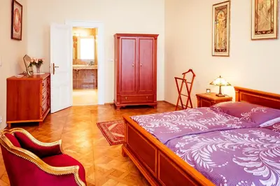 a bedroom with a bed and two chairs in it at Apartment Vodičkova 11 in Prague