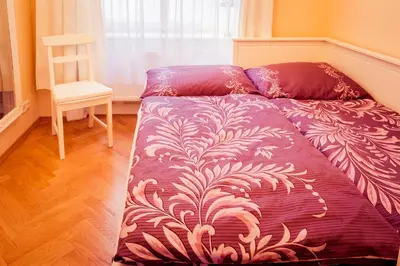 a bed with a purple comforter and a chair in a room at Apartment Vodičkova 11 in Prague