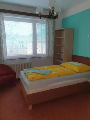 a bedroom with a bed with yellow sheets and a window at Pension Beránek in Prague