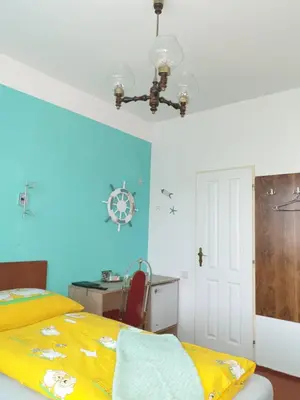 a bedroom with a yellow bed and a desk at Pension Beránek in Prague