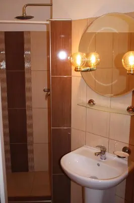 a bathroom with a sink and a shower with a mirror at Pension Beránek in Prague