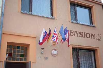 a group of flags hanging from the side of a building at Pension Beránek in Prague