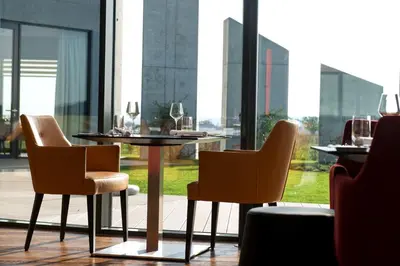 a table and chairs in a room with a window at MG Restaurace/Luxury Apartments in Mladá Boleslav