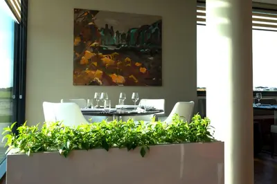 a dining room with a table and chairs and a painting at MG Restaurace/Luxury Apartments in Mladá Boleslav