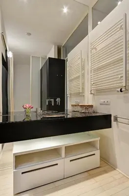 a kitchen with white cabinets and a black counter top at Historic Centre Apartments VI in Prague