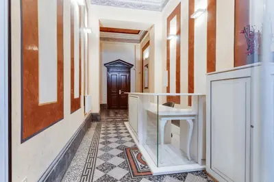 a hallway with orange and white walls and a wooden door at Hálkova Studio in Prague