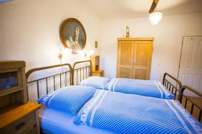 two beds in a bedroom with blue and white sheets at Penzion Ctrnactka in Rataje nad Sázavou