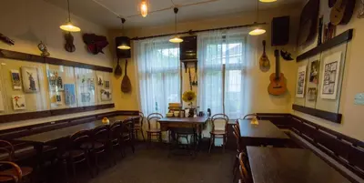 a restaurant with tables and chairs and guitars on the wall at Penzion Ctrnactka in Rataje nad Sázavou