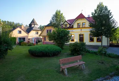 a bench in a yard in front of a house at Penzion Ctrnactka in Rataje nad Sázavou
