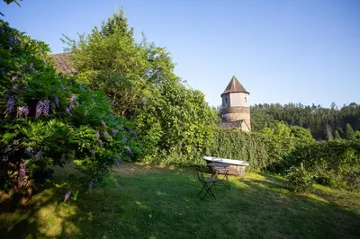 a garden with a table and a building in the background at Penzion Ctrnactka in Rataje nad Sázavou