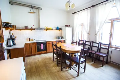 a kitchen with a wooden table and chairs and a table and a tablektop at Penzion Ctrnactka in Rataje nad Sázavou