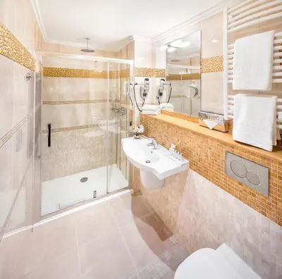 a bathroom with a shower toilet and a sink at Occidental Praha Wilson in Prague
